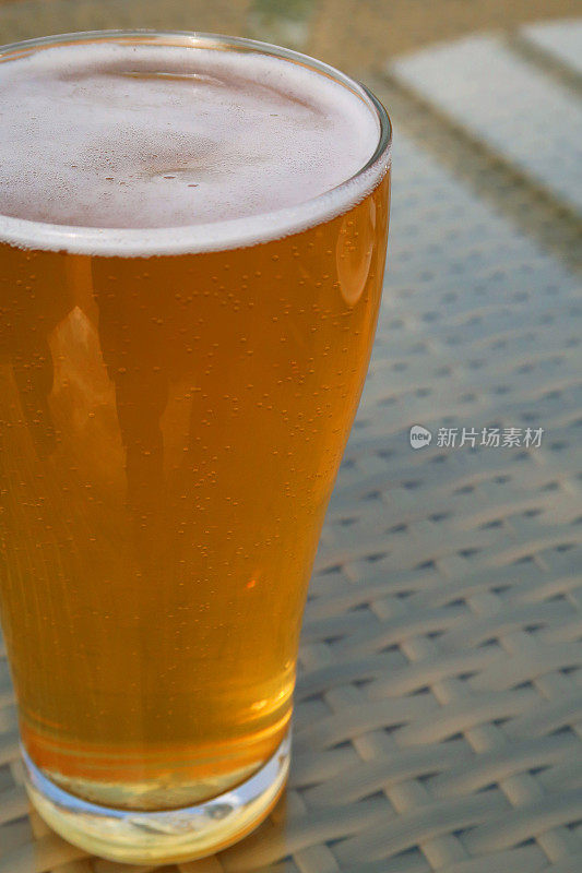 啤酒杯/金苹果苹果酒/啤酒照片的特写，显示泡沫泡沫的头，外面的啤酒杯在酒吧花园酒吧/餐厅